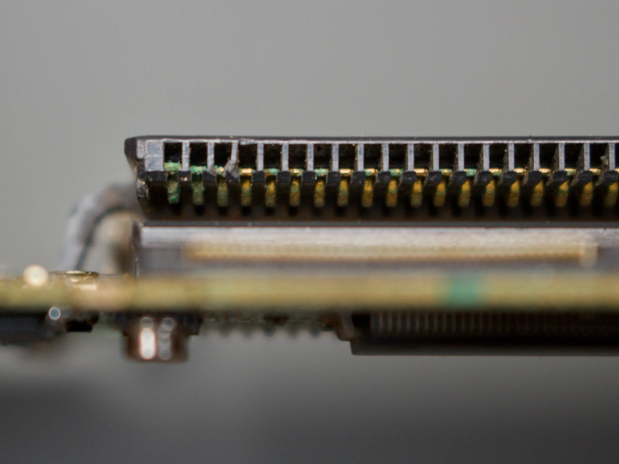 Side view of the Game Boy Advance cartridge connector showing green corrosion on several connector pins